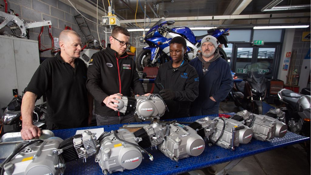 Students and tutors in automotive workshop 