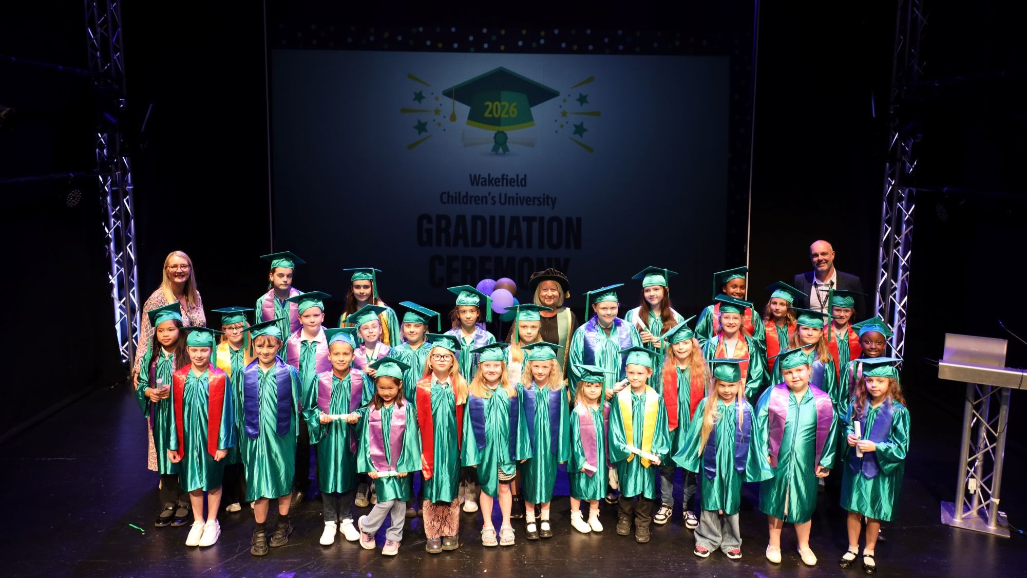 Children celebrate on stage at Wakefield College's Children's University graduation