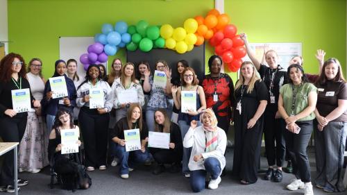 Photo of students and tutors with certificates and balloons.