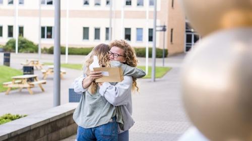 Students hugging with their results 