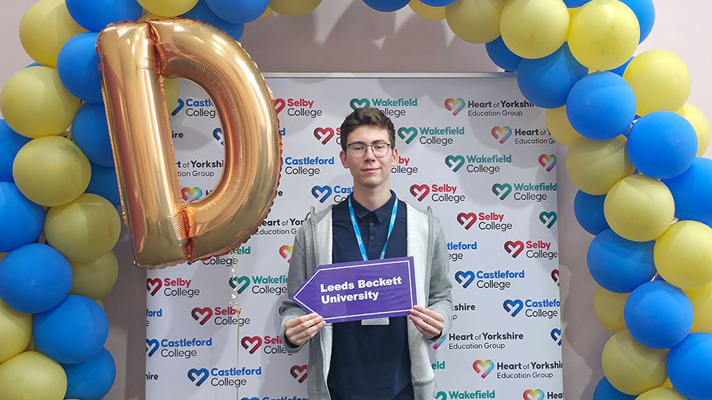 Student with university placard and balloons