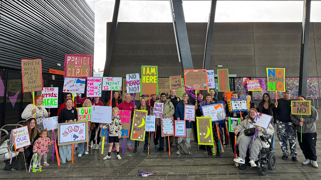 People holding up banners for reclaim the night march