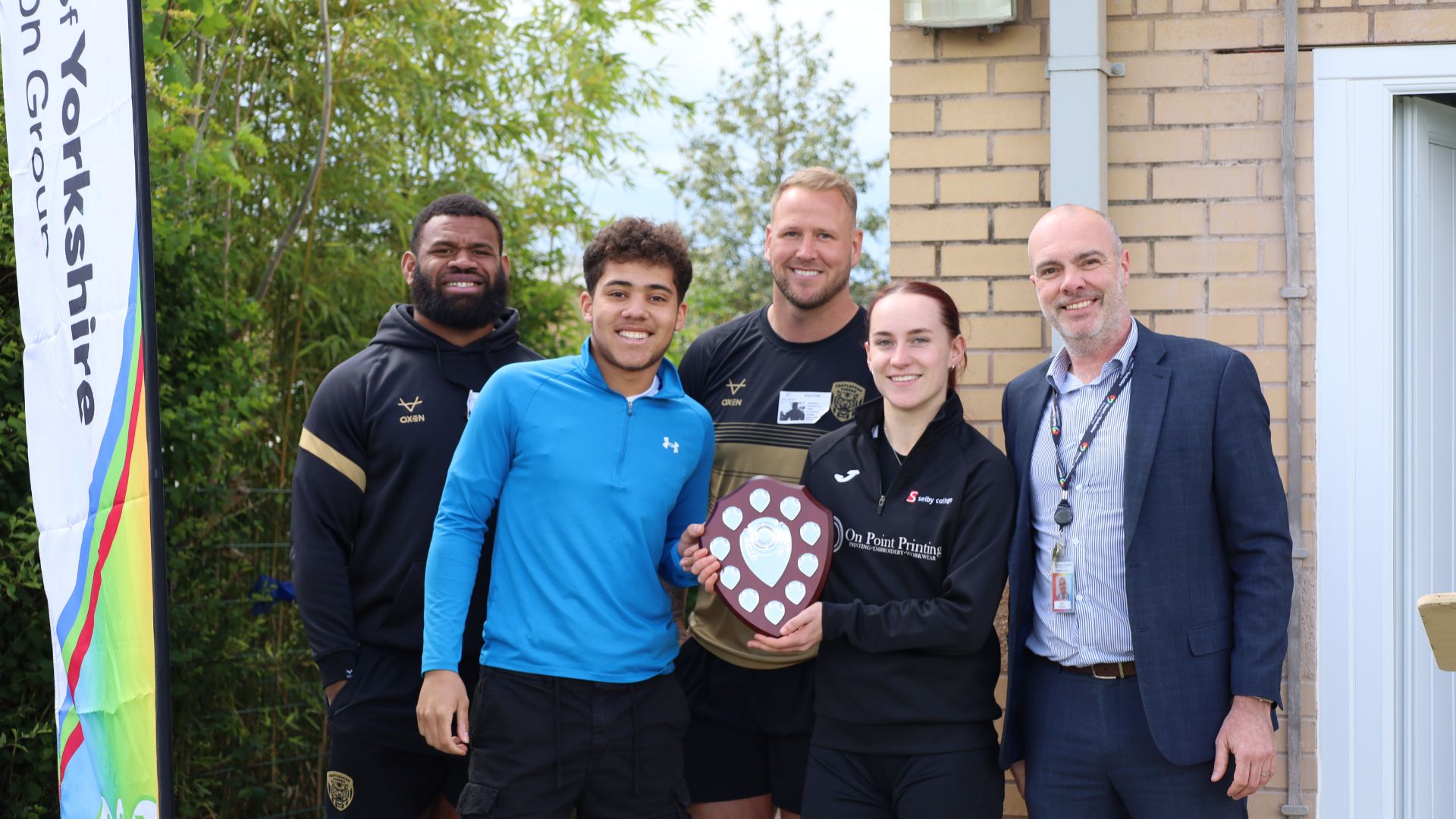 Students holding the varsity trophy