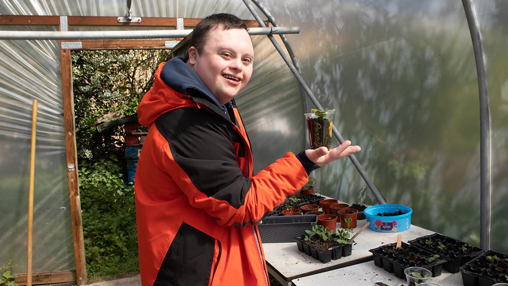 Student holding plant pot